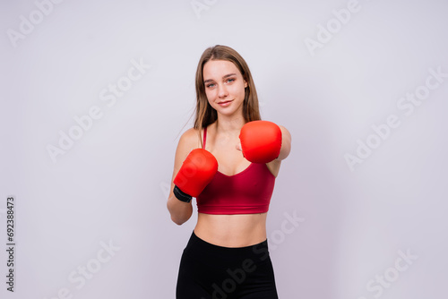 Woman boxer in gloves training on grey and yellow background © Ivan Zelenin