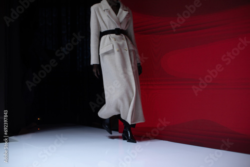 Fashion details of a beige long coat and high heels. Women's fashion and stylish accessories.