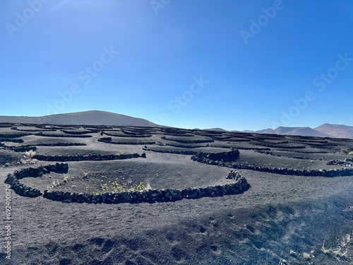Cone shaped hollows (geria) in volcanic mountain terrain near La Geria, Lanzarote, Canary Islands, Spain photo