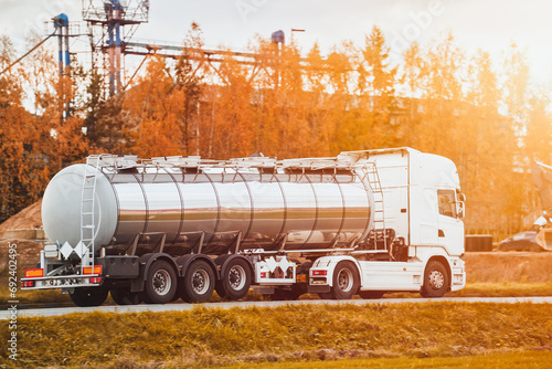 Dangerous goods transportation by semi truck with propane tank. The tank truck has a side view and shows hazard labels for high-temperature liquid and miscellaneous hazards. The truck follows the ADR photo