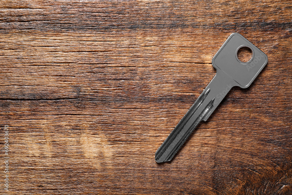 One key on wooden table, top view. Space for text One key on wooden table, top view. Space for text