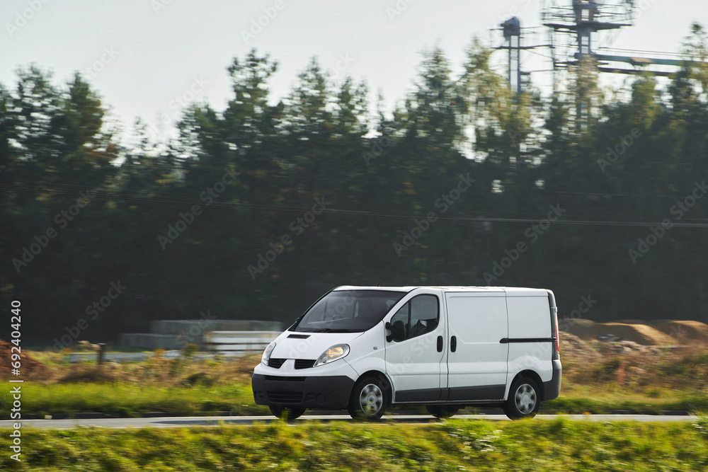 A white van on the road, shipping cargo and packages from the warehouse to the customers, showing the design and branding of their logistics service.