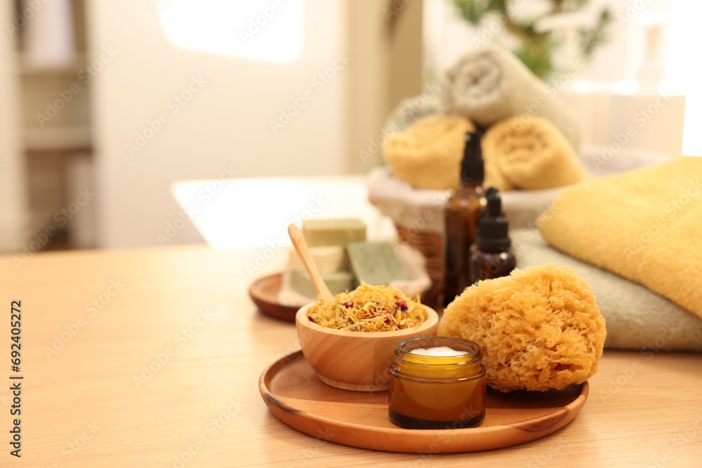 Dry flowers, loofah and jar with cream on wooden table indoors, space for text. Spa time Dry flowers, loofah and jar with cream on wooden table indoors, space for text. Spa time
