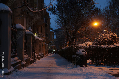 View of city street covered with snow in evening
