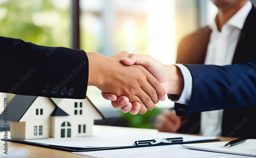 Real Estate Deal Concept: Handshake Between Businessmen in Front of House Model