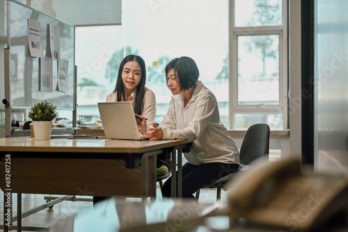 Senior businesswoman helping and explaining work process to new employees. © Prathankarnpap