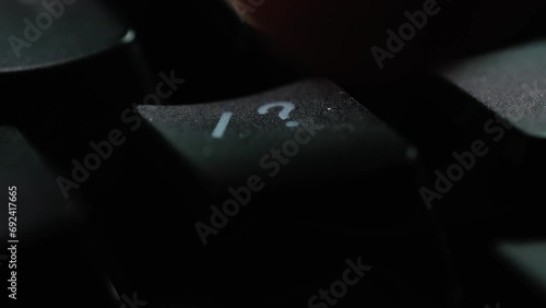 Keyboard button FORWARD SLASH. Macro shot of finger pressing QUESTION MARK button photo