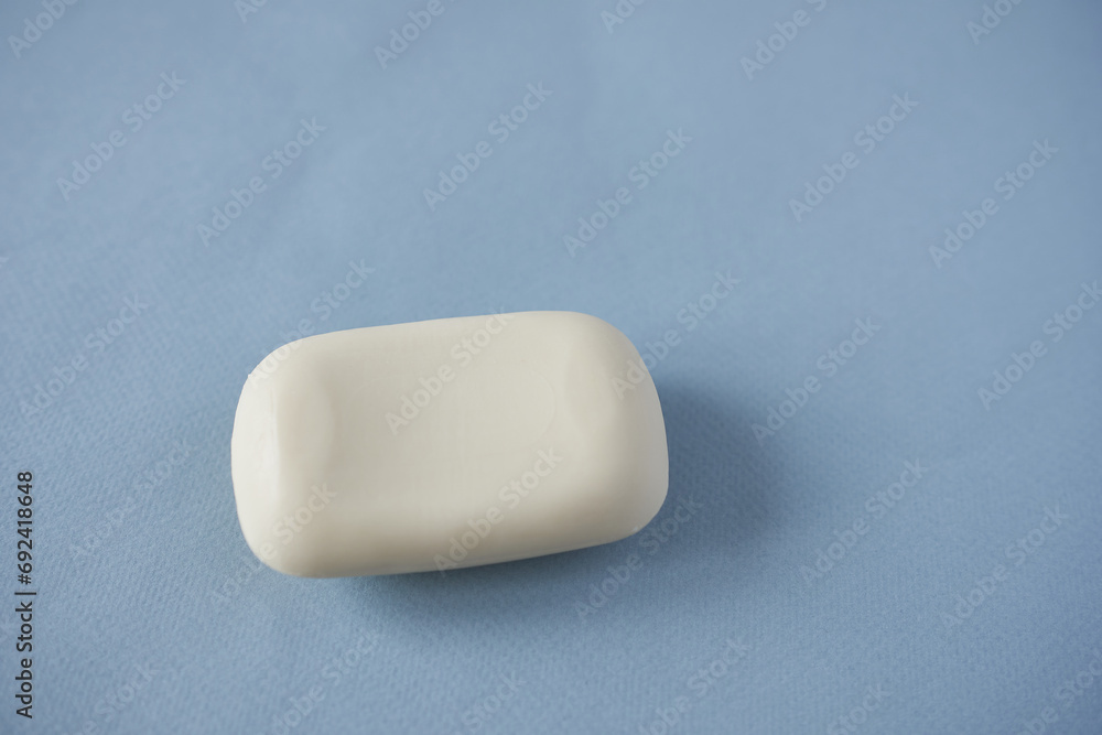 Bar of soap on blue background, close-up, selective focus Bar of soap on blue background, close-up, selective focus