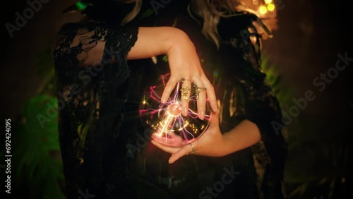 Fantasy woman witch gypsy girl predicts fate feel energy hand touching crystal ball in dark room. Mystical old art vintage style. Lady Fortune teller reading future. magic light wind blow hair fly. 4k photo