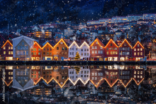 Winter dusk view of the famous Bryggen district at Bergen, Norway, decorated for Christmas with snow