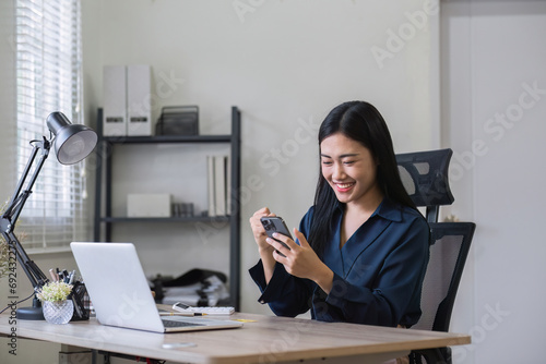 Young woman holding a credit card and using a laptop online shopping and pay online through an application on smartphone © wichayada