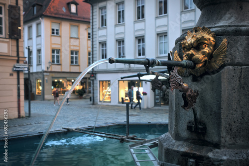 Fountain with a lion's head decoration on the street of an old German town. Ansbach, Bavaria Region Middle Franconia, Germany photo