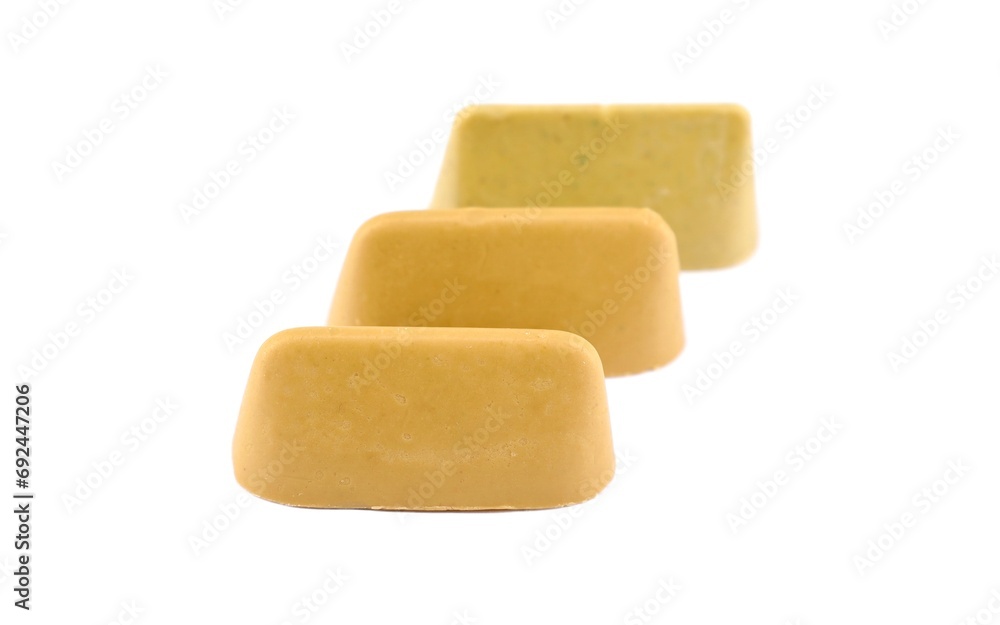 Three pistachio-flavored Gianduiotto on a white background. It'is a chocolate originally from Piedmont, in Northern Italy. Three pistachio-flavored Gianduiotto on a white background. It'is a chocolate originally from Piedmont, in Northern Italy.