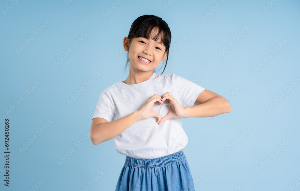 Portrait of Asian girl posing on blue background Portrait of Asian girl posing on blue background