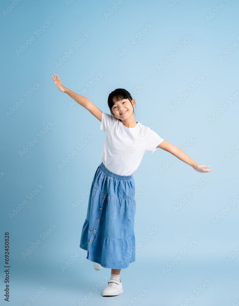 Full body image of an Asian girl posing on a blue background Full body image of an Asian girl posing on a blue background