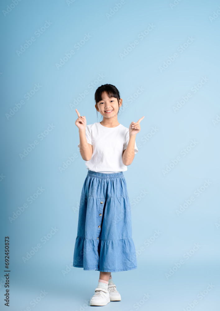 Full body image of an Asian girl posing on a blue background Full body image of an Asian girl posing on a blue background