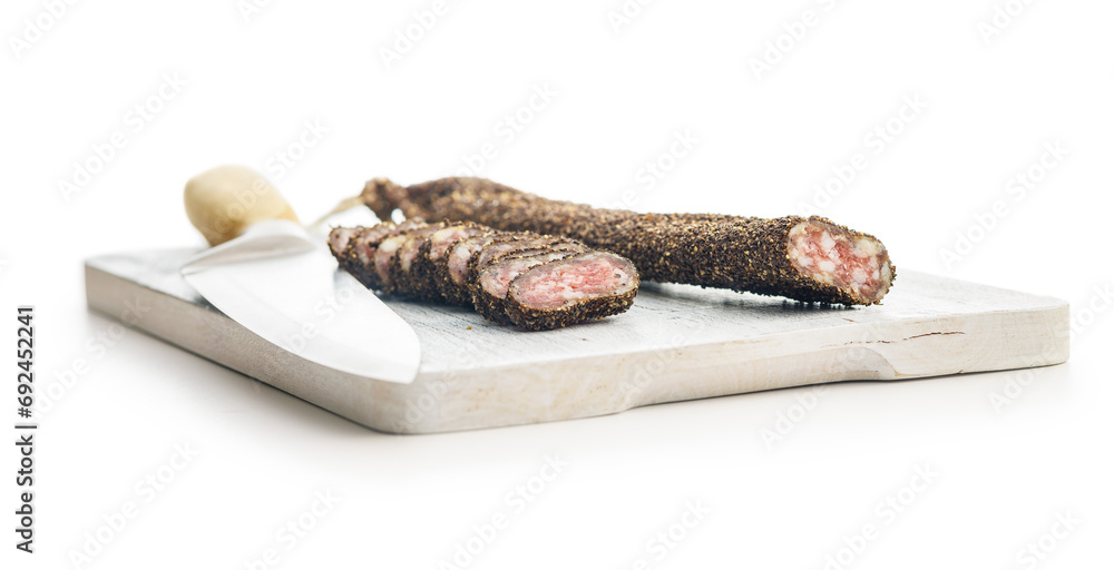 Obraz premium Smoked dried sausage. Sliced sausage on cutting board isolated on white background.