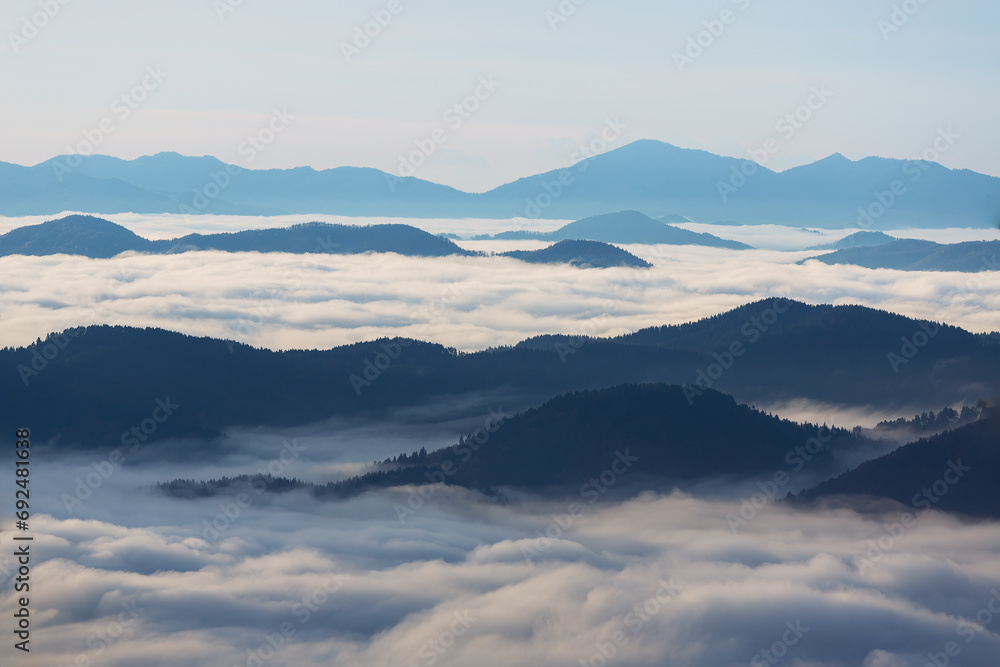 Sunrise over the mountain peaks with fog and clouds