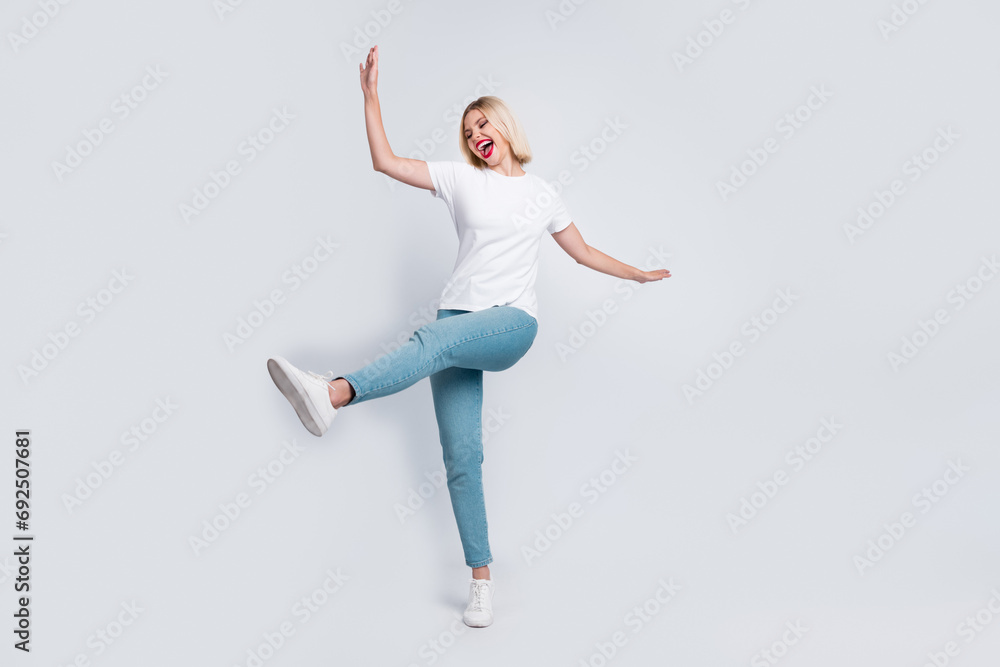 Full body photo of careless crazy eccentric woman wear stylish t-shirt jeans celebrate black friday isolated on gray color background