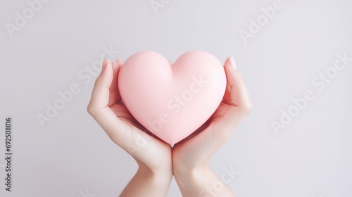 Volumetric pink heart holding a woman s hands close-up. Symbol of love. Happy Valentine s Day