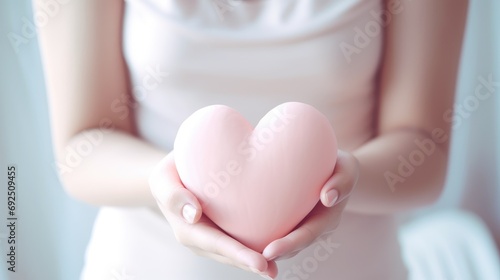Volumetric pink heart holding a woman s hands close-up. Symbol of love. Happy Valentine s Day