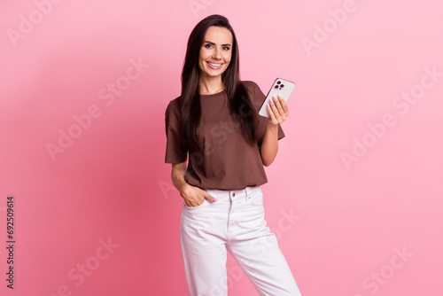 Photo of young woman brunette hair influencer use new apple iphone 15 pro max with high quality camera isolated on pink color background