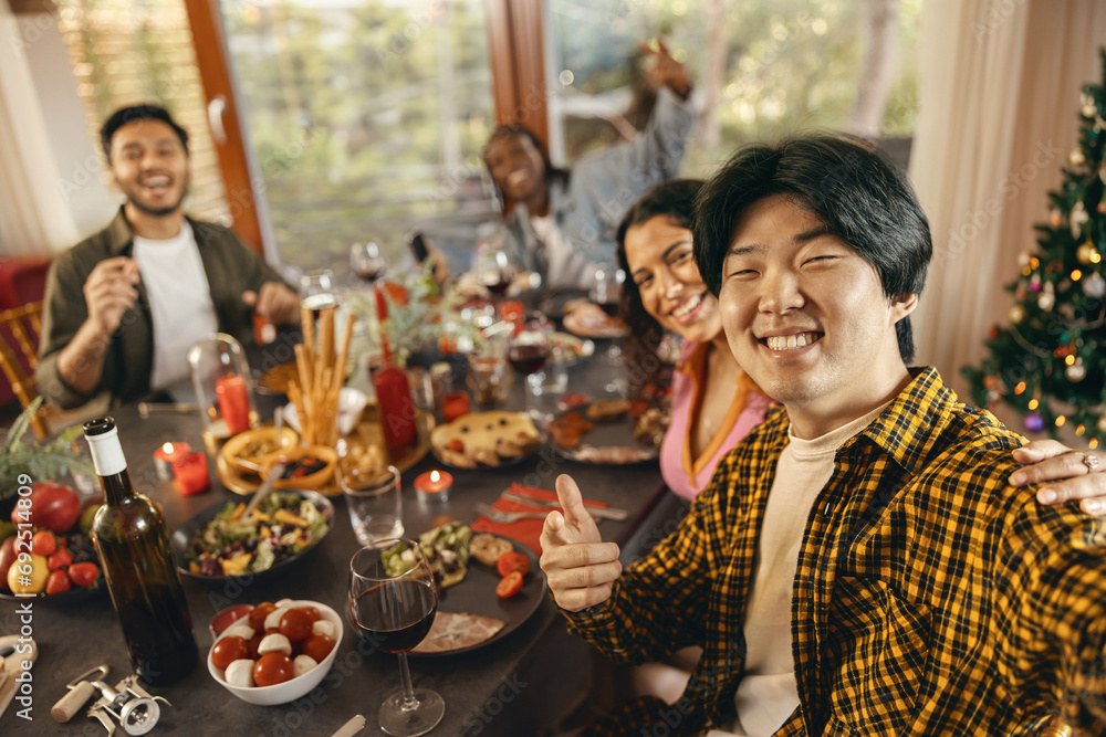Happy people taking selfie photo sitting on holiday dinner party at home and looks camera with smile Happy people taking selfie photo sitting on holiday dinner party at home and looks camera with smile