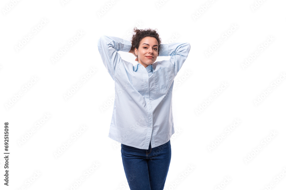 young pretty curly brunette secretary woman in a light blue shirt on a white background with copy space young pretty curly brunette secretary woman in a light blue shirt on a white background with copy space