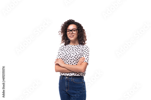 Photos a slender young stylish woman with a curly haircut dressed in a blouse with polk