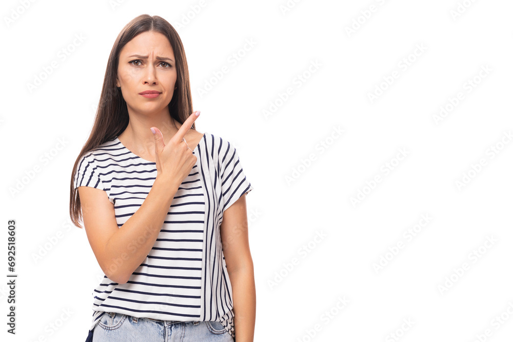 young positive pretty european brunette woman in a striped t-shirt points her finger on a white background with copy space young positive pretty european brunette woman in a striped t-shirt points her finger on a white background with copy space