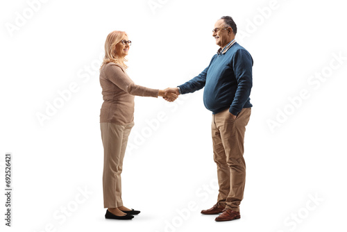 Full length profile shot of mature man and woman shaking hands