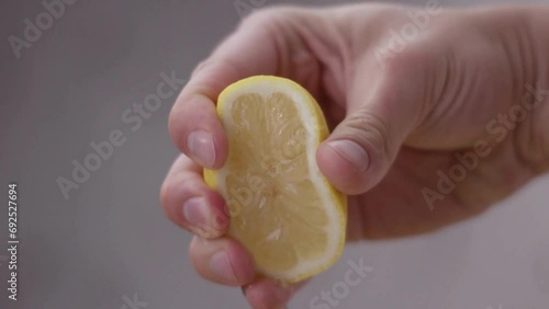 Scene of hand squeeze fresh lemon juice. Squeezing out fresh Lemon juice drains from the pulp.