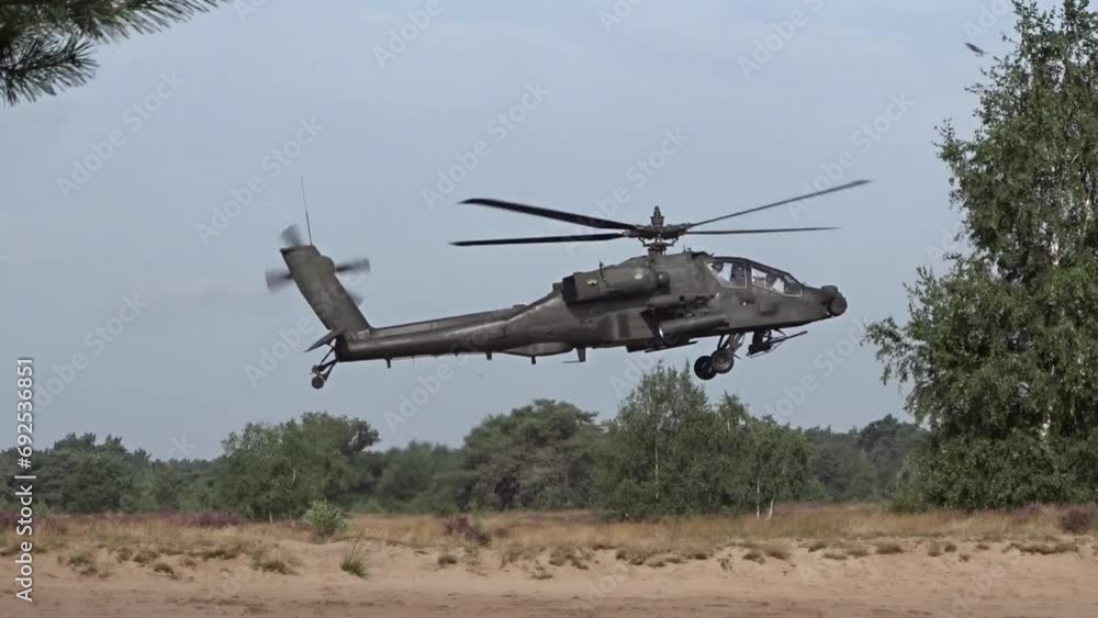 Military Helicopter hovering flying low over the ground between trees. Military Helicopter hovering flying low over the ground between trees.
