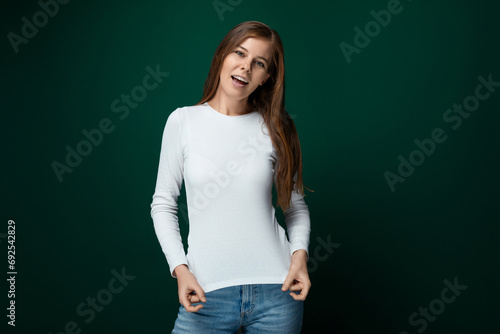 Young pretty woman with brown hair in a casual look on a green background