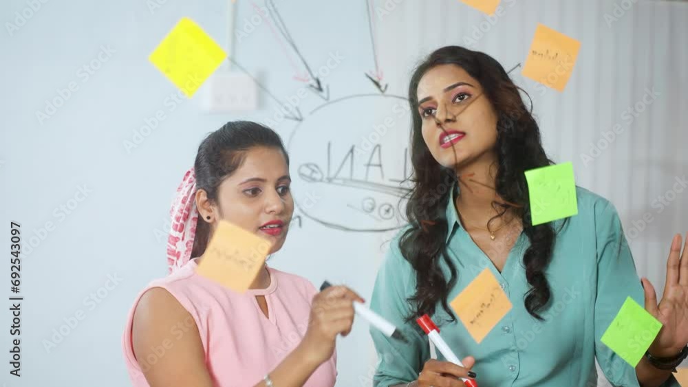 Female employees or coworkers busy planning at office for business development or to increase sales - concept of collaboration, problem solving and woman empowerment at workplace Female employees or coworkers busy planning at office for business development or to increase sales - concept of collaboration, problem solving and woman empowerment at workplace