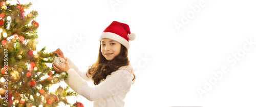 Christmas Eve, New Year, asian girl in white dress with cap on her head decorates Christmas tree.