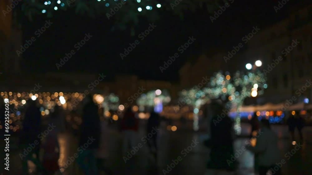 Blurred Christmas market in evening at town hall square in Krakow,Poland. Holidays, sale and retail concept Blurred Christmas market in evening at town hall square in Krakow,Poland. Holidays, sale and retail concept