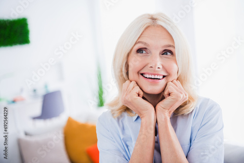 Portrait of dreaming smiling mature aged relaxed cute business lady touching cheeks admire to relax and spend free time at home indoors