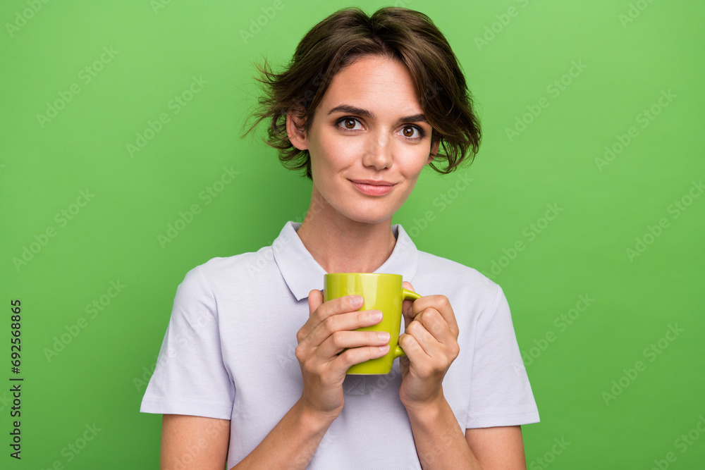 Photo of pretty adorable girl wearing stylish clothes hand hold cup sweet cacao isolated on green color background Photo of pretty adorable girl wearing stylish clothes hand hold cup sweet cacao isolated on green color background