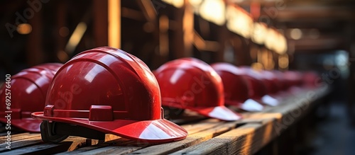 red safety helmet or hardhat, construction worker , is placed on wooden photo