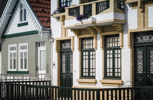 The city street is lined with charming beach houses, each with its own unique porch and window design (Costa Nova, Portugal)