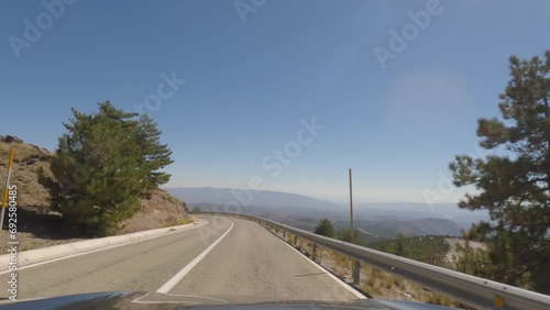 First person view, FPV, from dashcam of car driving mountain road from Calar Alto Observatory to Tabernas Desert in Almeria, Andalusia, Spain, Europe. Road trip in POV, with bright, sunny, clear sky photo