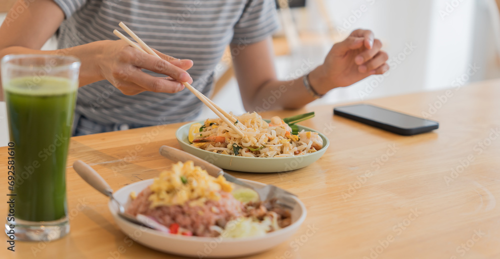 Asian Girl eating Thai food in kitchen counter Home delivery food feeling happy Asian Girl eating Thai food in kitchen counter Home delivery food feeling happy