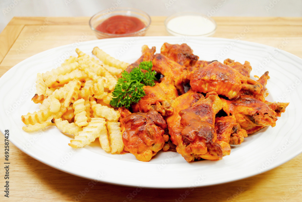 A Platter of Served Spicy baked Buffalo Wings and Crinkle Cut French Fries
