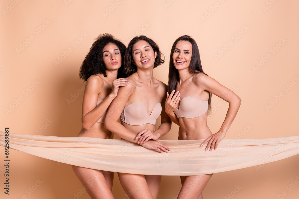 Studio photo of dreamy happy ladies dressed lingerie no filter skin covering textile smiling isolated pastel beige color background