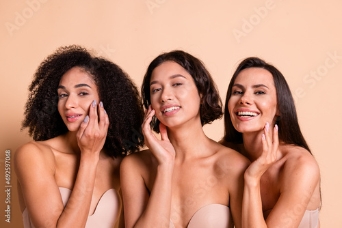 Studio photo of cheerful sweet ladies dressed lingerie no filter skin applying cream isolated pastel beige color background