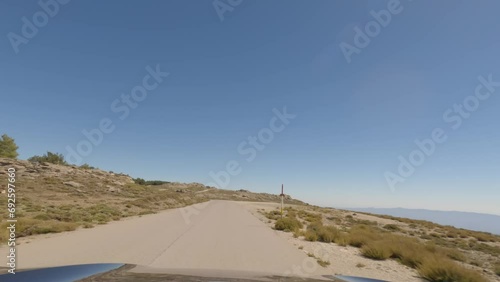 First person view, FPV, from dashcam of car driving mountain road from Calar Alto Observatory to Tabernas Desert in Almeria, Andalusia, Spain, Europe. Road trip in POV, with bright, sunny, clear sky photo