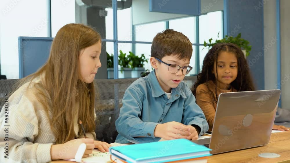 Diverse happy school kids using laptop computer together in classroom. Back to school Diverse happy school kids using laptop computer together in classroom. Back to school