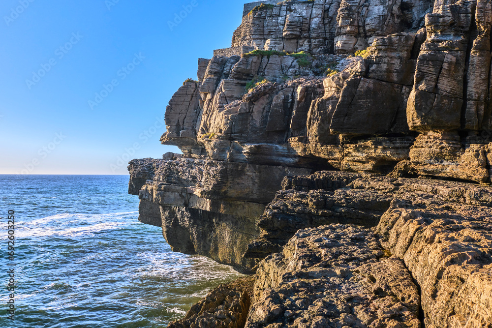 Eroded rocks and sea waves of Atlantic ocean coast on sunny day