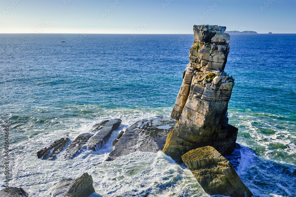 Sea waves and Nau dos Corvos rock near Peniche peninsula, Portugal at